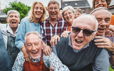 Joyful Seniors Taking a Group Selfie - Over-65 friends gathered at a countryside house, laughing and shouting together while capturing a festive moment.
